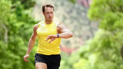 An athlete is running through the woods.